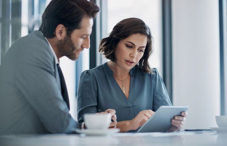 Two Colleagues Checking Stats On A Tablet