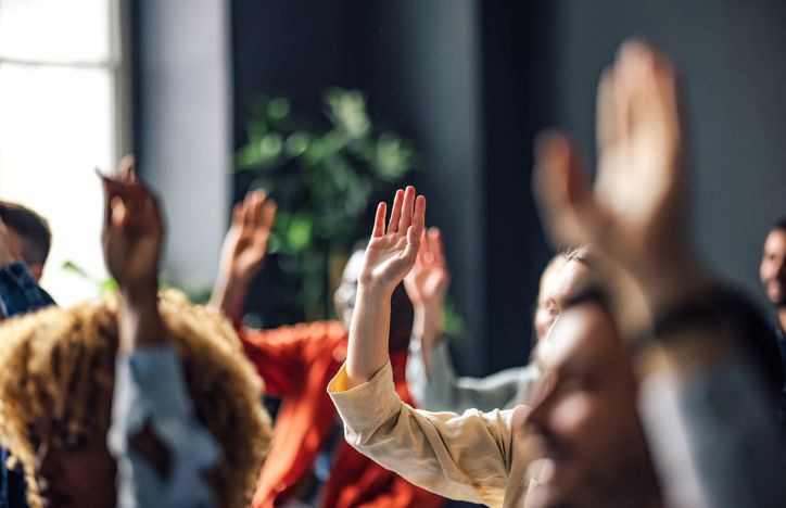 People Raising Hands In Seminar