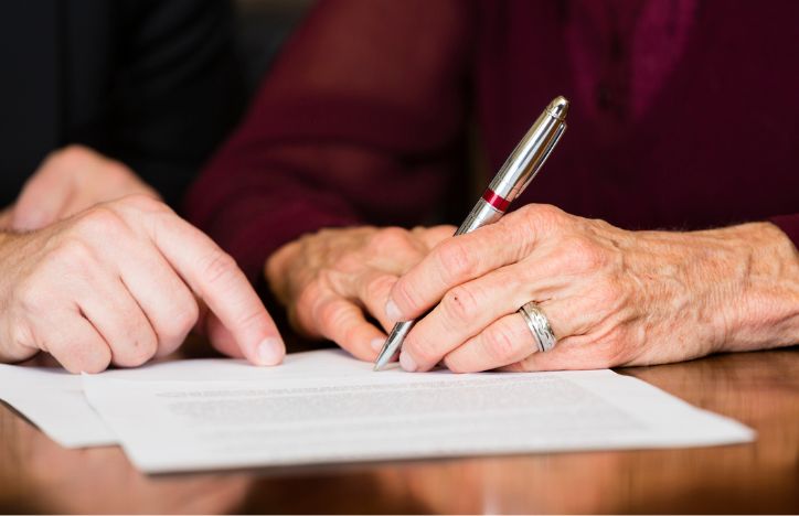 Two People Checking And Signing Document