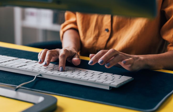 Close Up Of A Woman With Painted Nails Typing On A Keyboard
