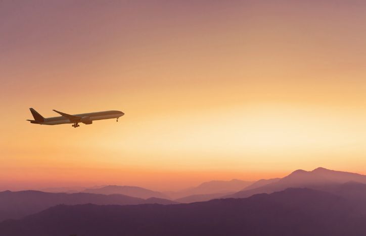 Plane In Sky At Sunset