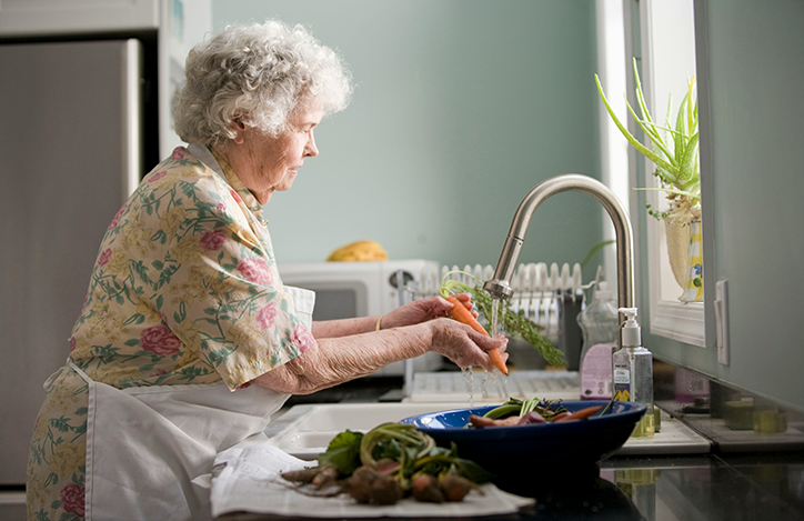 An elderly woman washing vegetables.png