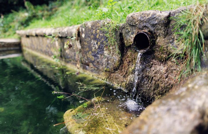 Water Draining Out Of Pipe Into A Stream