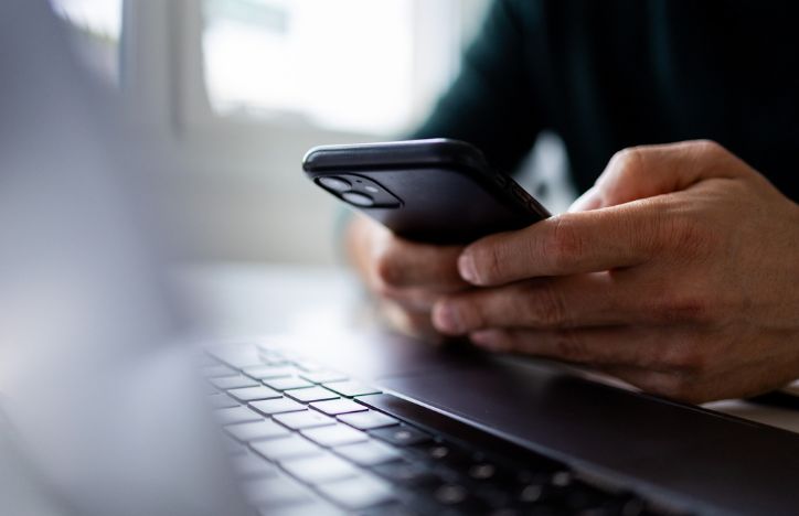 Man On Phone With Laptop In Front